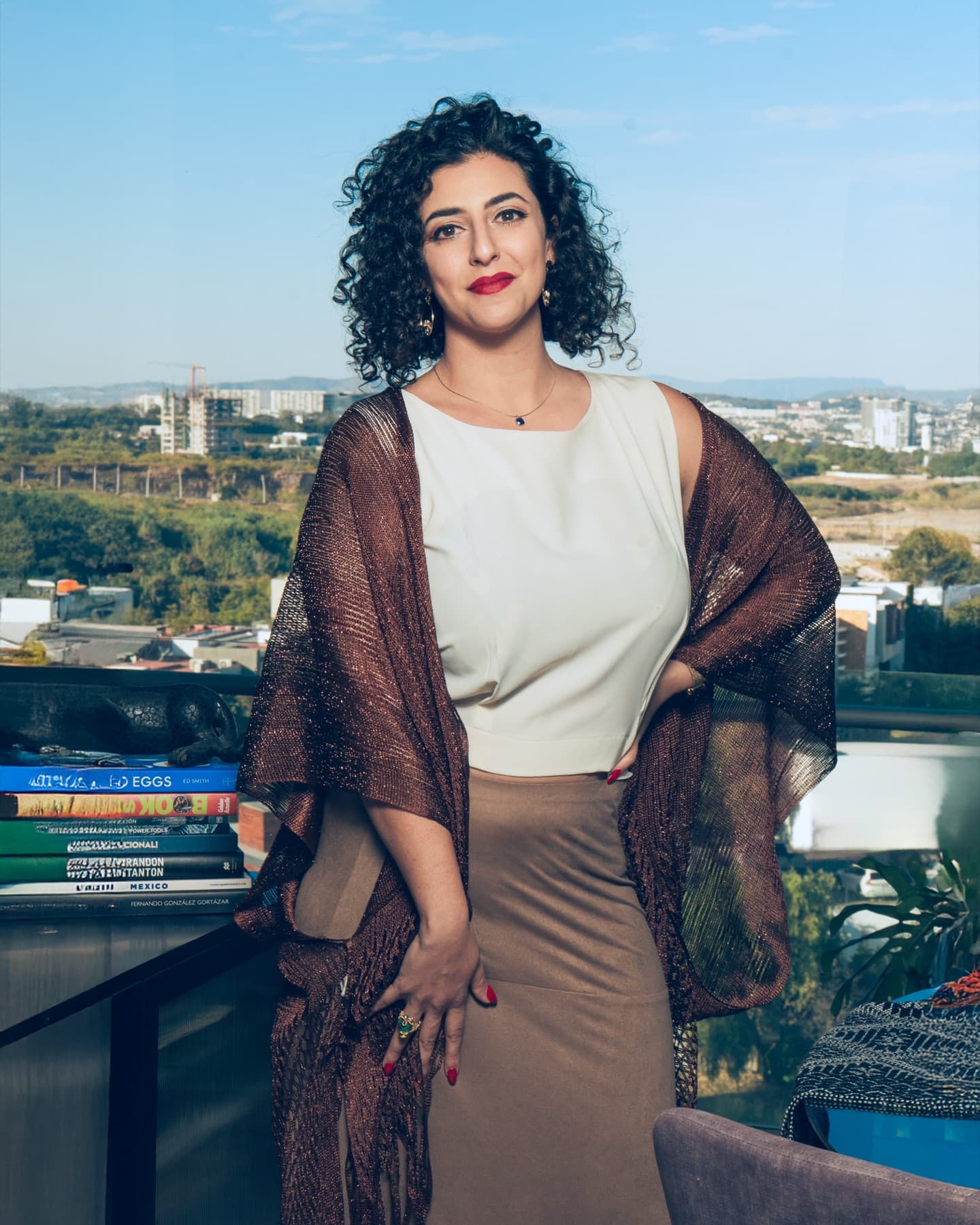 Asha Singh standing on a terrace with the city behind her.